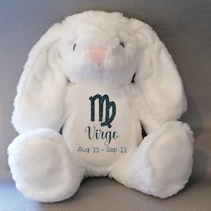 May include: White plush bunny with long ears, embroidered with the Virgo zodiac symbol and the dates Aug. 23 - Sep. 22.