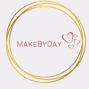 May include: A gold circle with two concentric rings, the text "MAKEBYDAY" in red, and four red hearts.