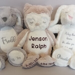 May include: Three plush stuffed animals, a gray bunny, a tan owl, and a white bunny. The gray bunny is embroidered with the name "Fredd", the date "12-09-20", and the weight "1-7oz". The tan owl is embroidered with the name "Jenson Ralph", the date "1-10-20", and the weight "6lbs 14oz". The white bunny is embroidered with the text "A hug from heaven for when you need it most" and the word "Grandad".