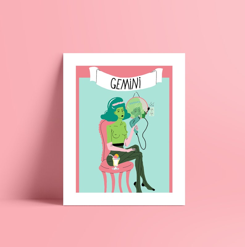 May include: A framed art print with a quirky illustration of a green-skinned figure seated on a pink chair, holding a mirror. The word "GEMINI" is displayed on a banner above. The background is light blue and pink.