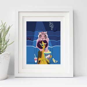 May include: A framed art print featuring a stylized illustration of a person in a movie theater. The person is wearing 3D glasses and holding popcorn. A pink tiger is perched on the person's shoulders. The print includes a cup with the word "FIZZ".