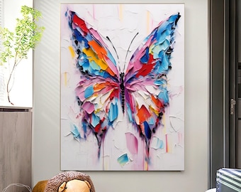 May include: A large, framed canvas art piece featuring a vibrant, textured butterfly. The butterfly's wings are a mosaic of bright colors, including red, blue, yellow, and pink, set against a white background. The artwork is a modern, abstract representation.