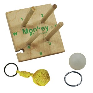 May include: Wooden game with four pegs and a white ball. The game is labeled "Monkey Fun Juice". The game is on a wooden base with the letters W, S, E, and N. A yellow knotted ball on a key ring is also included.