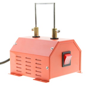 May include: A coral-colored foam cutter with a rectangular body, ventilation slots, and a red on/off switch. Two vertical metal rods are connected to the top, with a horizontal metal wire between them. The device is designed for cutting foam.