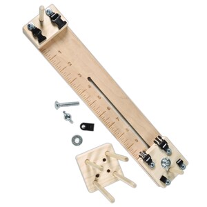 May include: Wooden dowel jig with a ruler, clamps, and a small wooden base with dowel holes. The jig is used to create precise dowel joints for woodworking projects.