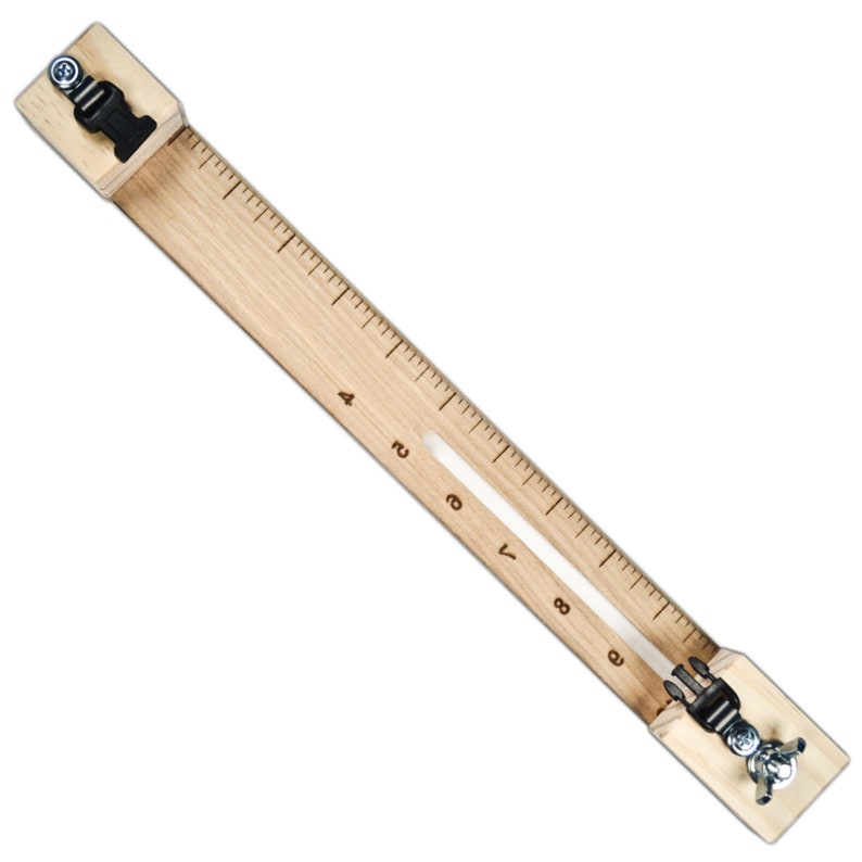 May include: A wooden ruler with two clamps on either end. The ruler has markings for inches and is 9 inches long.