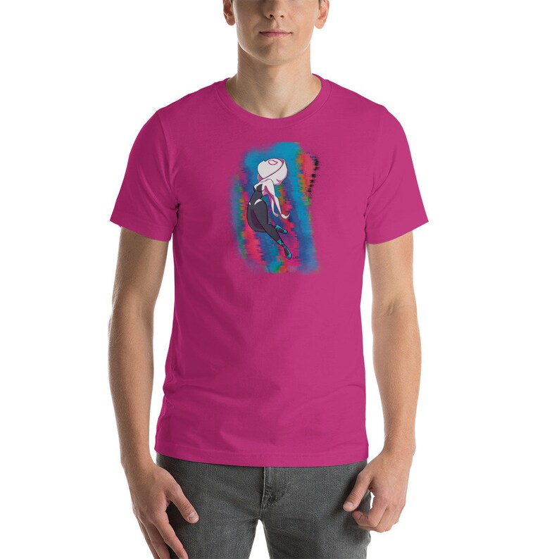 May include: A pink t-shirt with a graphic of a cartoon character in a black and white suit, with a white face and pink hair, standing in front of a colorful, abstract background.