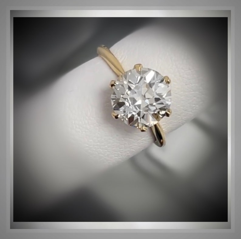 May include: A gold ring with a large, round, clear diamond.