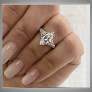 Pu&ograve; includere: Un anello di fidanzamento in argento con un grande diamante a forma di marquise. Il diamante &egrave; incastonato in una montatura a pav&eacute; con diamanti pi&ugrave; piccoli sulla fascia.