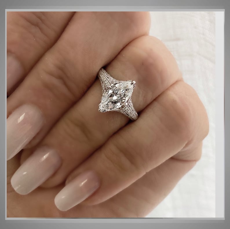 Pu&ograve; includere: Un anello di fidanzamento in argento con un grande diamante a forma di marquise. Il diamante &egrave; incastonato in una montatura a pav&eacute; con diamanti pi&ugrave; piccoli sulla fascia.