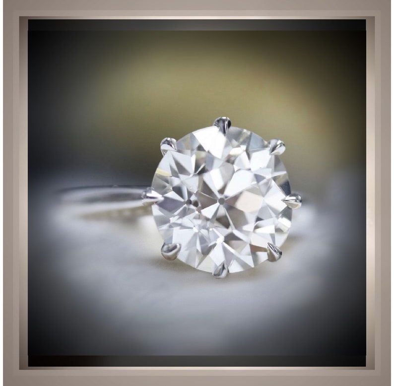 May include: A large, clear, round diamond ring with a silver band.