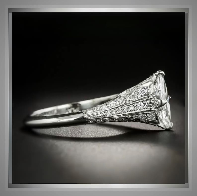 Pu&ograve; includere: Un anello di fidanzamento in platino con un grande diamante ovale incastonato a griffe. La fascia &egrave; decorata con diamanti pi&ugrave; piccoli in un design delicato e intricato.