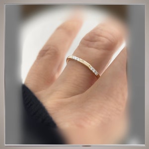 May include: A thin gold band with small diamonds set in a row.