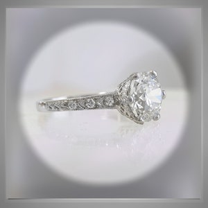 May include: A silver engagement ring with a large, round, clear diamond center stone and smaller diamonds set in the band.