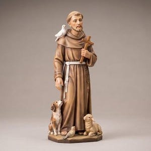 Puede incluir: Una estatua de madera pintada a mano de una figura barbuda con una túnica de monje marrón y un cinturón de cuerda blanca. La figura sostiene una cruz de madera, tiene una paloma blanca en el hombro y está rodeada por un perro, un cordero y un pájaro en la base.
