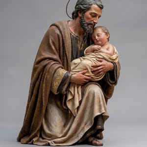 May include: A detailed statue of Saint Joseph cradling the infant Jesus. The figures are draped in flowing robes of brown and beige hues, with gold accents. Saint Joseph has a halo and a serene expression, while the baby sleeps peacefully.