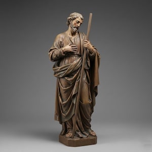 May include: A detailed wooden statue of a man with a beard, holding a staff. The figure is dressed in draped robes, with one hand on his chest. The statue has a weathered, antique appearance, with subtle color variations.
