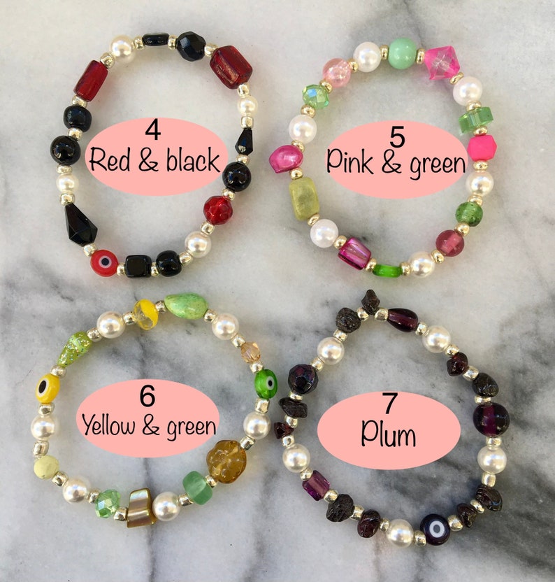 May include: Four bracelets with different colored beads. The bracelets are made with white pearls and various colored glass beads. The bracelets are labeled with numbers and color combinations: 4 Red & black, 5 Pink & green, 6 Yellow & green, 7 Plum.