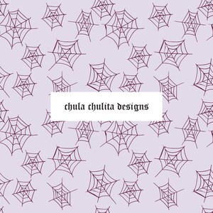 Könnte beinhalten: Ein nahtloses Muster mit einem sich wiederholenden Design aus lila Spinnweben auf einem helllila Hintergrund. Der Text "chula chulita designs" ist in der Mitte des Bildes platziert.