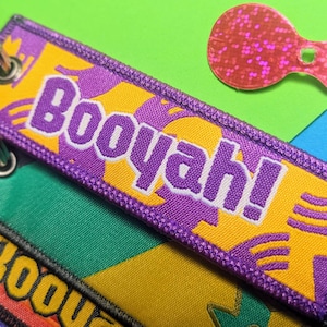 May include: Purple and yellow key chain with the word "Booyah!" in white lettering.