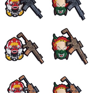 May include: Six embroidered patches featuring a stylized demon face with horns and a red, yellow, and green color scheme. Each patch has a black and gray rifle with a scope attached to the top.