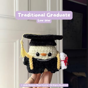 May include: A crocheted graduation-themed plushie in black, yellow, and white. The plushie wears a graduation cap and gown, and holds a diploma tied with a red ribbon. The text "Traditional Graduate" and "Low sew" are visible.