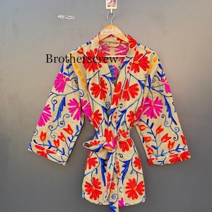 Op de afbeelding: Beige geborduurde kimono-achtige badjas met een bloemenpatroon in rood, roze en blauw. De badjas heeft een striksluiting en driekwart mouwen. De tekst "Brotherscrew" is zichtbaar.