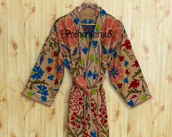 May include: A beige robe with a floral pattern in shades of red, blue, green, and pink. The robe has a white trim and a tie belt.