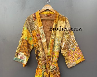 May include: A yellow and gold patchwork quilted robe with a tie belt. The robe has a floral pattern and is made of silk.