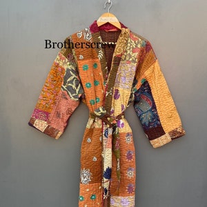 May include: A patchwork robe with a tie belt, featuring a variety of fabric patterns in shades of orange, brown, and purple. The robe is hanging on a wooden hanger against a gray background. The text "Brotherscrew" is visible on the robe.