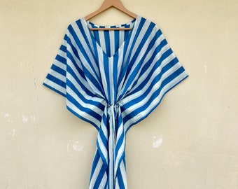 May include: A blue and white striped kaftan with a V-neck and short sleeves. The kaftan is tied at the waist.