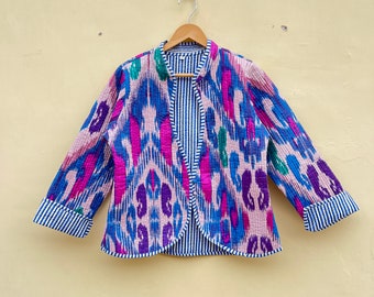 May include: A blue and pink patterned jacket with a white and blue striped lining. The jacket has long sleeves and a mandarin collar.
