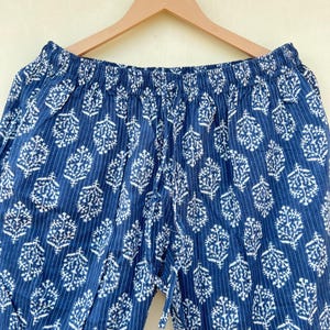 K&ouml;nnte beinhalten: Blaue Baumwollhose mit wei&szlig;em Blumenmuster und elastischem Bund.