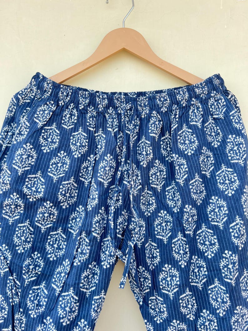 K&ouml;nnte beinhalten: Blaue Baumwollhose mit wei&szlig;em Blumenmuster und elastischem Bund.