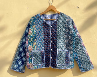 May include: A blue quilted jacket with a floral print and a button closure. The jacket has a striped lining and two pockets.
