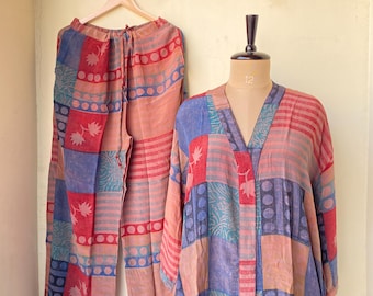 Puede incluir: Un conjunto de pijama de dos piezas con un diseño de patchwork. El conjunto incluye pantalones sueltos y una parte superior estilo kimono. La paleta de colores presenta tonos rojos, azules y melocotón. La parte superior se muestra en un maniquí.