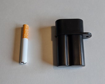 May include: A black metal cigarette case with a hinged lid and a small loop on the side. The case is designed to hold two cigarettes. A single white and orange cigarette is shown next to the case.