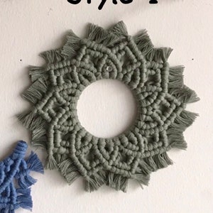 May include: A green macrame wall hanging with a circular design and fringe. The wall hanging is labeled "Style 1".