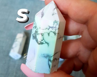 Puede incluir: Una punta de cristal marmoleada blanca, azul y verde con una punta puntiaguda. El cristal mide aproximadamente 5 cm de largo.