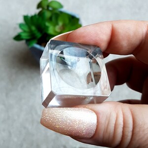 Puede incluir: Un porta anillos de cristal transparente con base cuadrada. El porta anillos est&aacute; vac&iacute;o y parece ser de cristal.