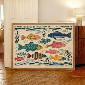 May include: A rectangular framed art print featuring a stylized illustration of various fish in shades of blue, yellow, orange, and pink. The design includes wavy lines, seaweed motifs, and dotted patterns on a cream background with the text thebonafidesa.