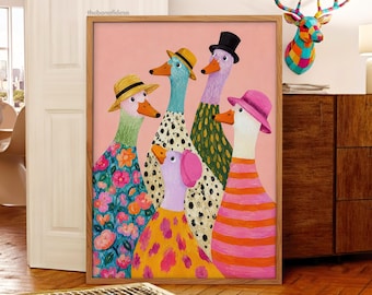May include: A framed art print featuring five stylized geese against a solid pink background. The geese wear colorful hats and patterned clothing, including floral, polka dot, and striped designs. The text thebonafidesa is printed in the top corner.