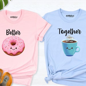 May include: Two t-shirts with a donut and a coffee cup graphic. The pink shirt says "Better" and the blue shirt says "Together".