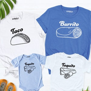 May include: A set of three white t-shirts with a blue baby onesie. The shirts feature a black and white illustration of a taco, a burrito, and two taquitos. The text on the shirts reads "Taco", "Burrito", and "Taquito".