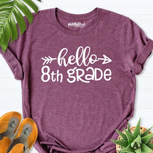 May include: A purple t-shirt with the text "hello 8th grade" in white with an arrow on either side of the word "hello".