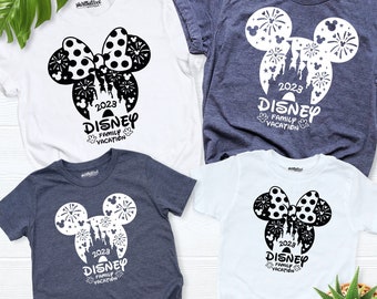 May include: Four t-shirts with a black and white silhouette of Mickey Mouse's head with fireworks and the text "2023 Disney Family Vacation". Two shirts are white and two are dark blue.