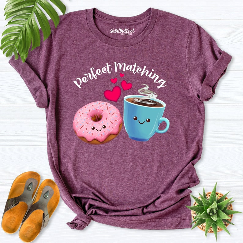 May include: A purple t-shirt with the text "Perfect Matching" and a pink donut and a blue coffee cup with smiling faces.