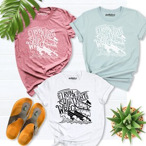 May include: Three t-shirts with a graphic design of a ship and the text "I run a ship tight wreck". The shirts are in pink, light blue, and white.