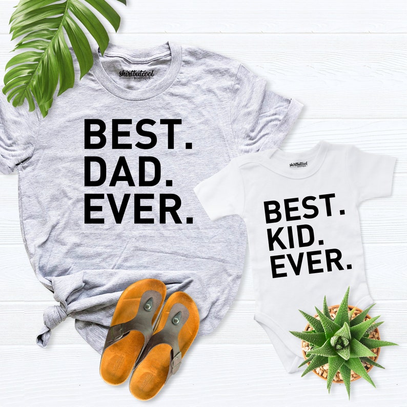 May include: A gray t-shirt with the text "BEST. DAD. EVER." and a white bodysuit with the text "BEST. KID. EVER.".