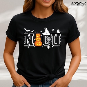 May include: Black t-shirt with a Halloween-themed design. The design features the letters "NCU" in a white, blocky font, with a stack of three carved pumpkins, a witch's hat, a spider web, and a ghost. Bats and stars complete the design.